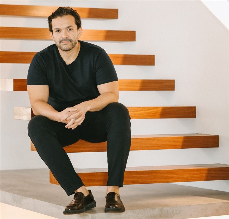 Bruno Ivanoff de preto, sentado numa escada de madeira flutuante