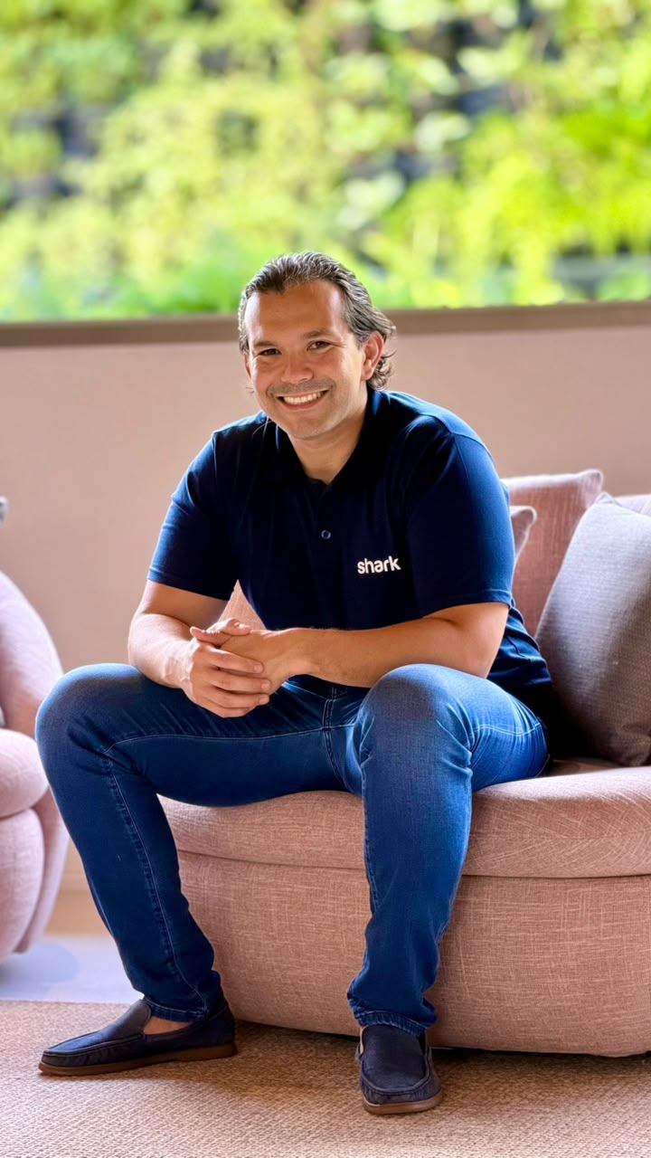 Bruno Ivanoff sorrindo, de polo azul-marinho da Shark